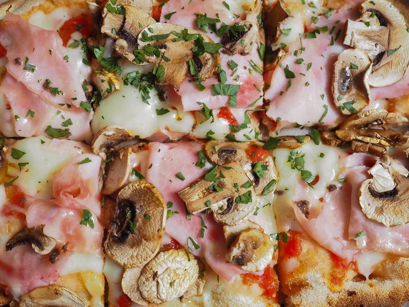 Four seasons pizza with mushrooms ham and artichokes